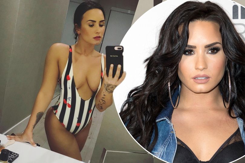 Demi Lovato flashes major cleavage in plunging black and white swimsuit as she poses up a storm for sizzling selfie